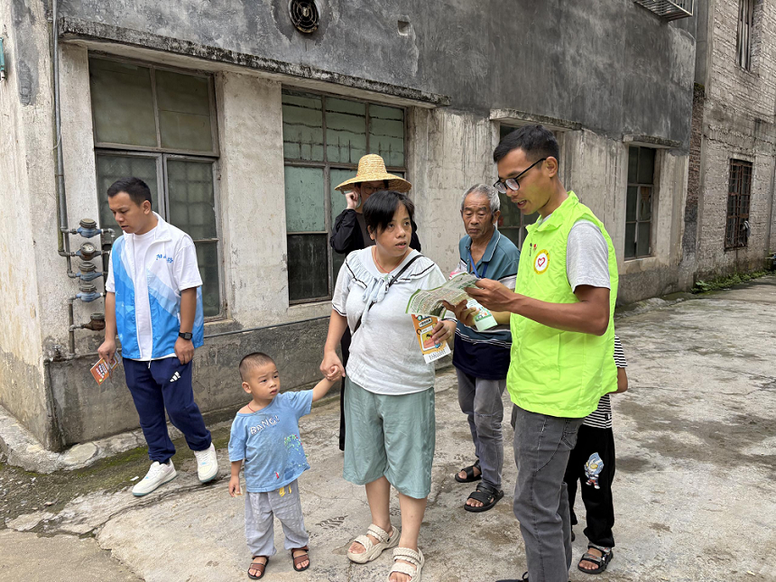黨員向社區(qū)居民發(fā)放宣傳資料.png